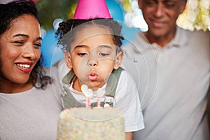 Girl, birthday party and blow candles with cake, celebration and support with applause, hat and happy in family home
