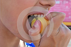 Girl bites fresh fruit  close up. Healthy teeth at the child