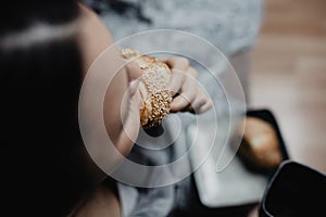 Girl biting a croissant and wearing a grey bath rope