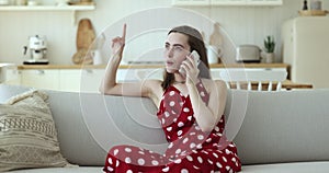 Girl blab on cellphone sit on sofa at home
