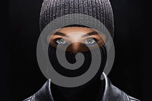 Girl in black balaclava. Beautiful female eyes under Mask