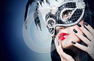 Girl in black carnival mask with manicure