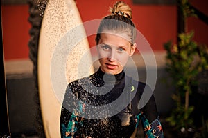 Girl in the black diving suit standing under the shower