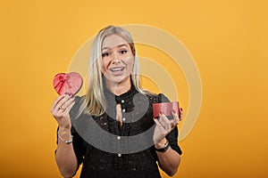 Girl in black dress happy woman shows off red surprise gift in form of heart box