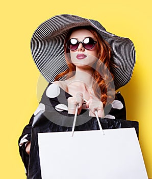 Girl in black dress and hat with shopping bags