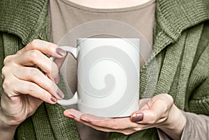 Girl in black dress is holding white mug. Mockup for Halloween gifts design.