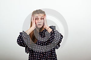 Girl in black dress upset unhappy woman Shocking problem holding hands over head