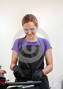 The girl in black gloves hairdresser mixes hair dye. photo