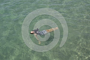 A Girl with black hair laying in the ocean