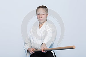 A girl in black hakama standing in fighting pose with wooden jo