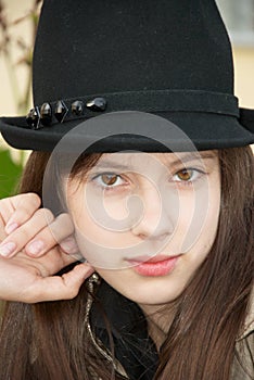 Girl in a black hat. Close-up