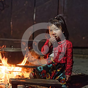 Girl from Black Hmong tribe sitting by fire