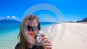 Maumere - A girl with a shell on the beach photo