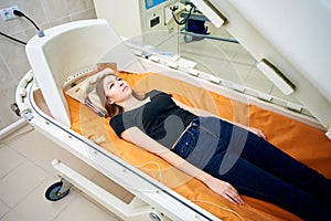 A girl in a black T-shirt lies in a hyperbaric chamber, oxygen therapy