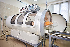 A girl in a black T-shirt lies in a hyperbaric chamber, oxygen therapy