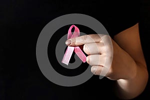 A girl in a black t-shirt with a pink ribbon on her chest is fighting cancer. Breast cancer awareness month. The concept of breast