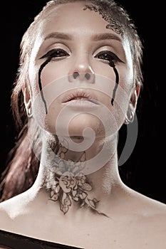 Girl with black tears from eyes and lace pattern on face and neck