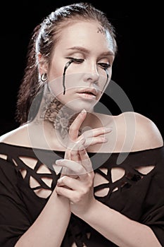 Girl with black tears from eyes and lace pattern on face and neck