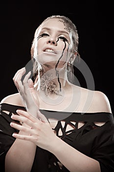 Girl with black tears from eyes and lace pattern on face and neck