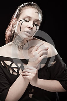 Girl with black tears from eyes and lace pattern on face and neck