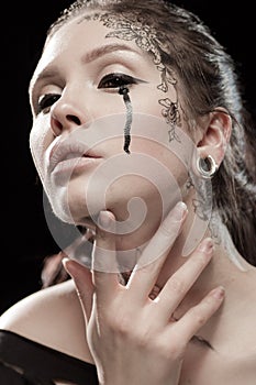 Girl with black tears from eyes and lace pattern on face and neck