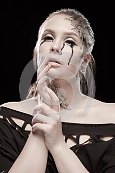 Girl with black tears from eyes and lace pattern on face and neck