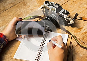 Girl with blank cell phone, diary and old camera