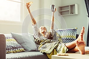 Girl in blanket relaxing on couch in living room