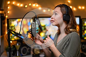 Girl blogger or radio host, working with a microphone, reading podcasts or news on the air. Homely and cozy atmosphere, work at