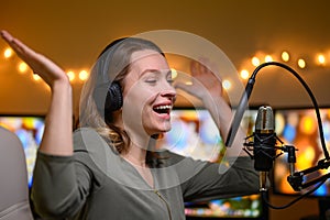 Girl blogger or radio host, working with a microphone, reading podcasts or news on the air. Homely and cozy atmosphere, work at