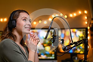 Girl blogger or radio host, working with a microphone, reading podcasts or news on the air. Homely and cozy atmosphere, work at