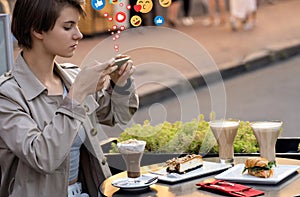 Girl blogger sit at cafÃ© table take food photo for instagram get likes.