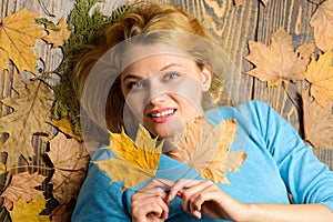 Girl blonde lay on wooden background with orange leaves top view. Fall and autumn season concept. Woman pretty lady