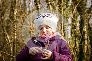 Girl and blossoming white snowdrop photo