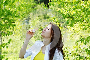 Girl blow bubbles in spring