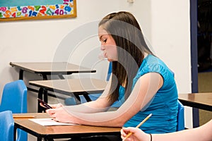 Girl blowing bubble and texting in class