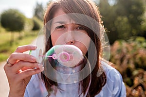 Girl blowing bubbles outdoor. Focus on lips.