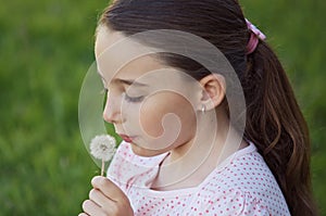 Girl blowing dandelion