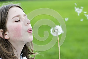 Girl blowing dandelion