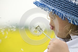 Girl blowing dandelion