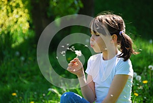 Girl blowing dandelion photo