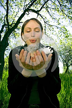 girl blowing dandelion seeds