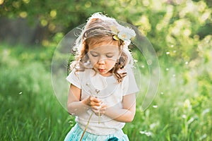 girl blowing dandelions flower selective focus. Allergy season.