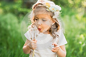 girl blowing dandelions flower selective focus. Allergy season.