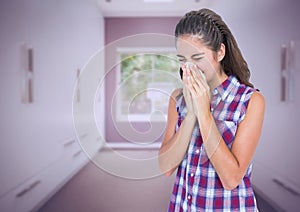 Girl blowing her nose in tissue in long room