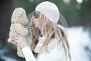 Girl blowing kisses to scruffy teddy bear