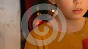 Girl blowing out candle, making wish on Christmas, faith in miracle, closeup