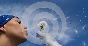 Girl blowing seeds out of a dandelion