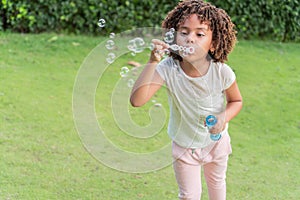 Girl blowing soap bubbles in the open air