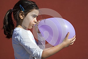 Girl blowing up balloon
